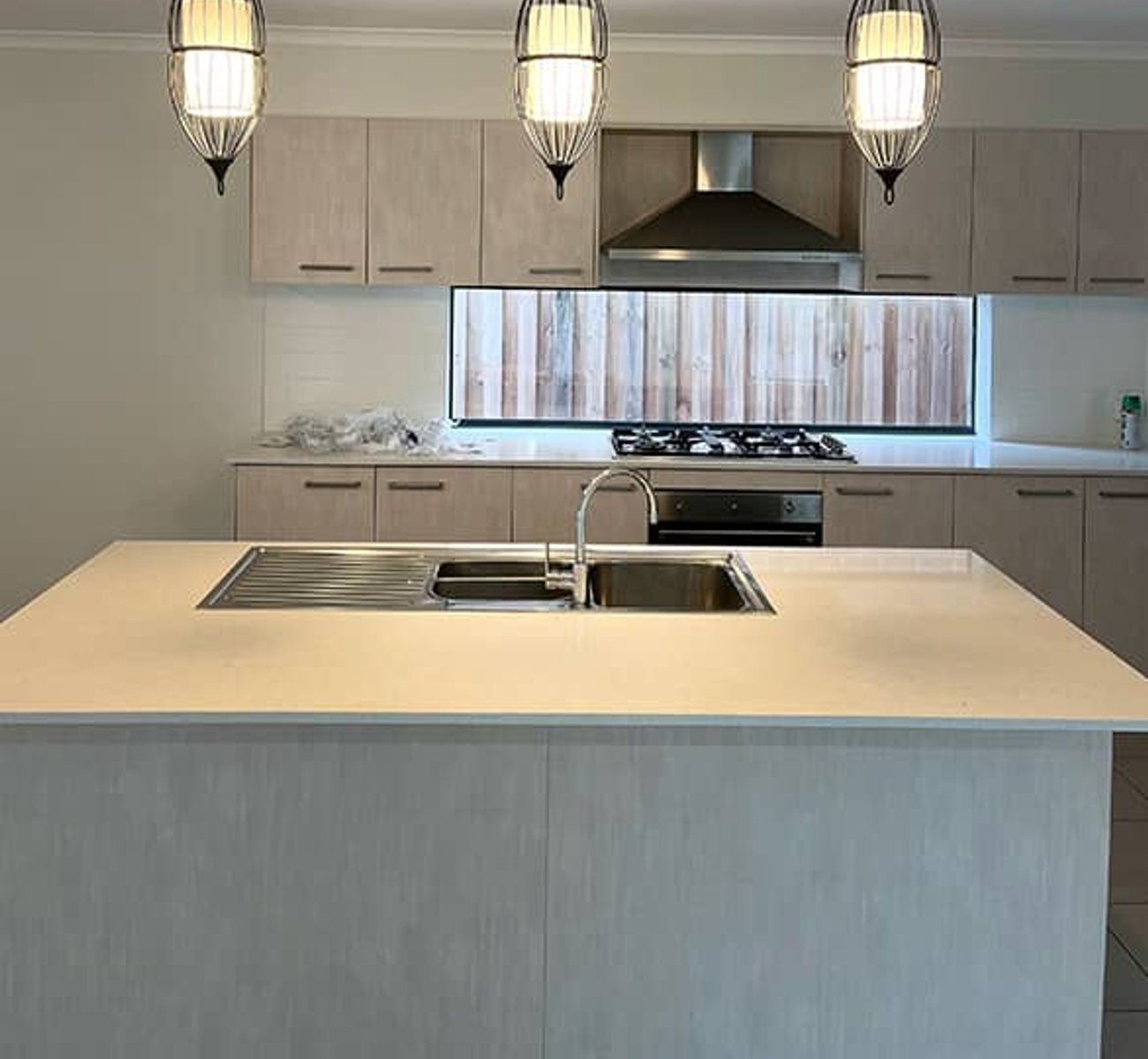Professional electrician installing a modern electric cooktop in a stylish kitchen
