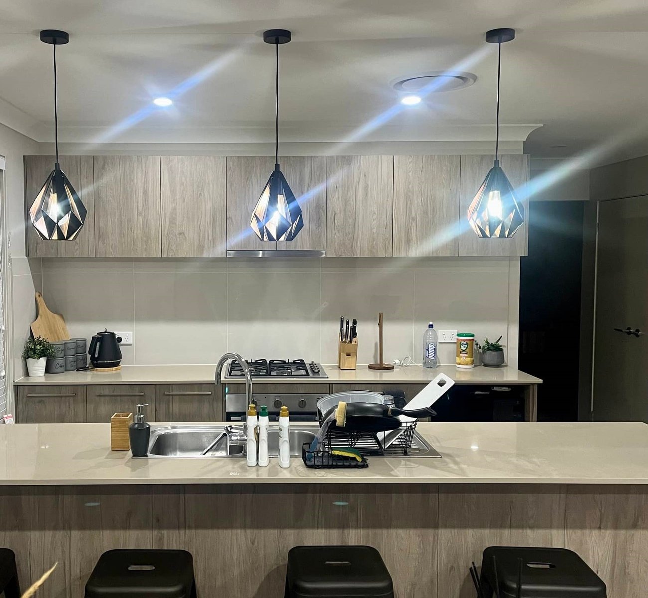 ESER Electrical technician installing a modern induction cooktop in a contemporary kitchen