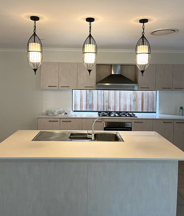 Professional electrician installing a modern electric cooktop in a stylish kitchen